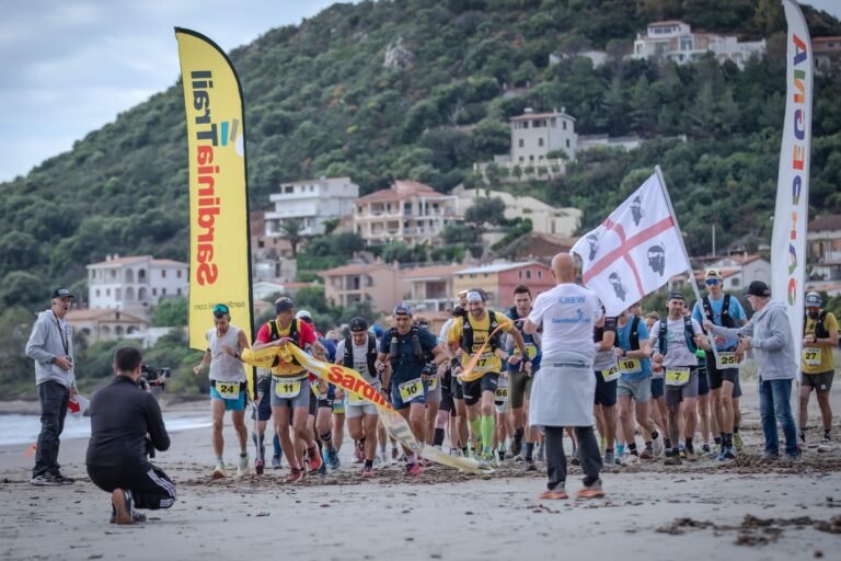 Partenza del Sardinia Trail sulla spiaggia con la bandiera sarda